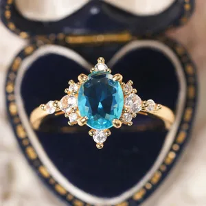 Anello con gemma di cristallo blu placcato oro design fiocco di neve elegante.