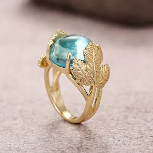 Detalle de primer plano del elegante anillo de hoja de ginkgo con piedra de luna simulada.