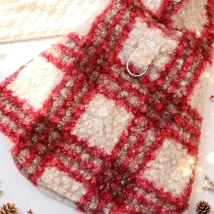 Close-up detail of red white plaid pet fleece cape with metal D-ring for winter.