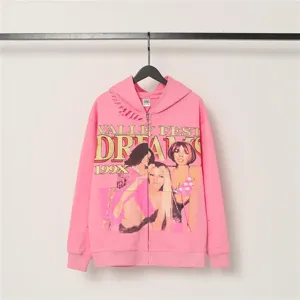 Pink vintage graphic zip hoodie detail showing distressed rips, chest print and metal zipper.