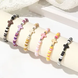 Gros plan détaillé de bracelets colorés en perles d'argile polymère avec pendentif croix.