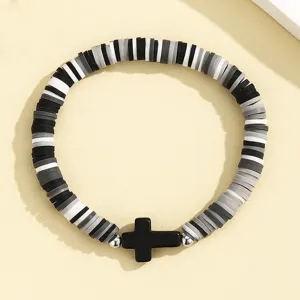 Vue détaillée du bracelet de perles heishi noir gris blanc avec pendentif croix bijoux boho