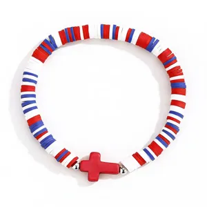 Vue détaillée des perles d'argile heishi colorées avec pendentif croix rouge et cordon élastique.