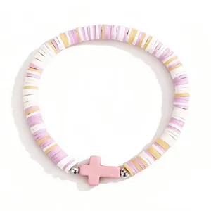 Gros plan détaillé du bracelet de perles en argile polymère bohème avec croix rose et disques.