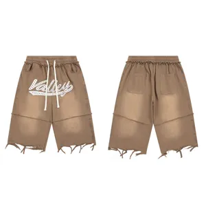 Washed brown streetwear denim shorts featuring colorful rhinestone studs and frayed hems.