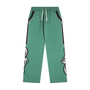 Green casual trousers for men and women, featuring contrast side stripes and streetwear style.