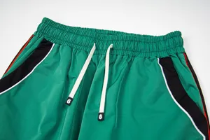 Detailed close-up of green casual sports pants waistband with adjustable drawstrings.
