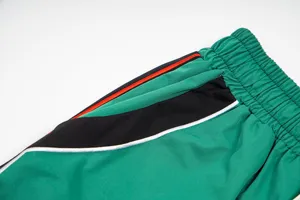 Detail view of athletic pants elastic waistband and colorful side stripes casual wear.