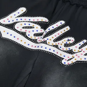 Close-up detail of high street rhinestone embroidered casual shorts showing sparkling colorful crystals.