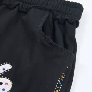 Detailed close-up of black washed casual shorts pocket and rhinestone embroidery craftsmanship.