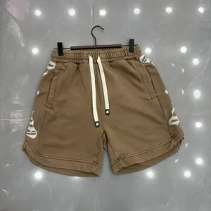 Vista dettagliata di pantaloncini casual marroni lavati con ricamo laterale e coulisse.