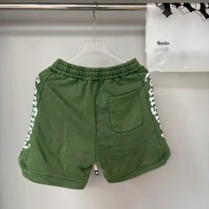 Pantaloncini casual lavati verdi con ricamo gotico laterale e vita elastica per tutti.