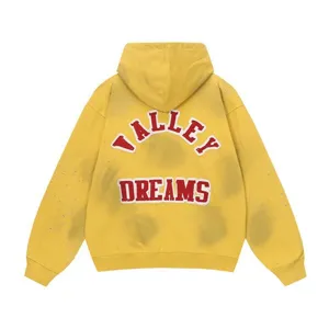 Back detail view of the yellow streetwear hoodie featuring rhinestone embellishments and letters.