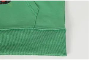Green casual streetwear hoodie detail shot featuring a ribbed hem and front pocket design.