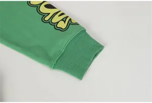 Close-up of green hoodie sweatshirt sleeve cuff with ribbed design and cool street style print.