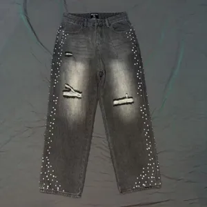 Close-up of vintage washed distressed denim jeans with sparkly rhinestone side details.