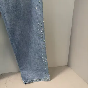 Light blue washed denim jeans detail featuring sparkling rhinestone embellishments on side seam.