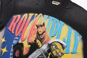 Camiseta gráfica vintage negra con letras de diamantes de imitación y detalles desgastados.