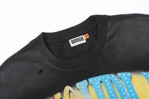 Detalle de camiseta de manga corta con estampado de letras de estrás Rough&Play y etiqueta.