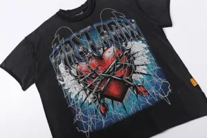 Close-up detail of black washed streetwear graphic t-shirt with rhinestone heart print.