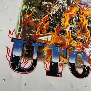 Streetwear t-shirt detail showing rhinestone embellishments and urban fire graphic print.