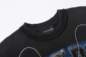 Close-up detail view of black washed short sleeve t-shirt featuring rhinestone embellishment.