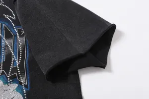 Close-up detail of black washed short sleeve t-shirt sleeve with rhinestone graphic design.