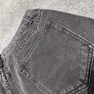 Close-up detail of dark wash denim shorts pocket and stitching craftsmanship, casual style.