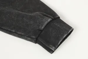 Detailed close-up of the washed black hoodie sleeve cuff, featuring vintage textured fabric.
