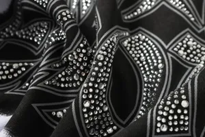 Detailed shot of black graphic rhinestone t-shirt fabric with high street geometric design.