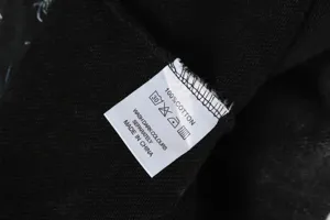 Close up view of the garment wash care label showing 100 percent cotton and wash instructions.