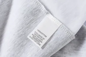 Cotton t-shirt inner care label detail closeup view showing 100% cotton fabric and text.