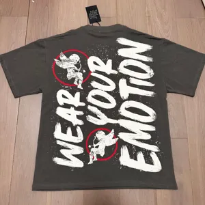 Camiseta gris oscura de manga corta con gran texto blanco en la espalda y angelitos.
