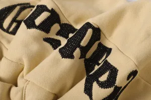 Primo piano di pantaloncini casual streetwear alla moda con ricami di lettere nere in evidenza.