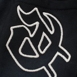 Vista ravvicinata di dettaglio di pantaloncini streetwear neri con logo ricamato.