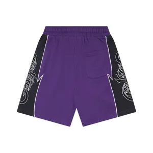 Detail view of purple casual shorts featuring black side panels with gothic print graphics.