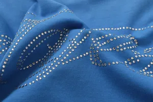 Blue cotton fabric t-shirt detail featuring sparkling rhinestone script letters and high quality.