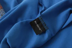 Blue washed short sleeve t-shirt detail shot, featuring a custom black brand woven label.
