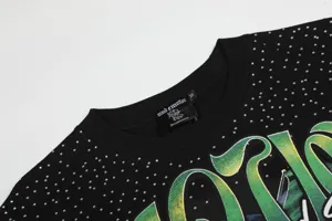 Primer plano de los detalles de la camiseta streetwear negra con pedrería y gran gráfico.