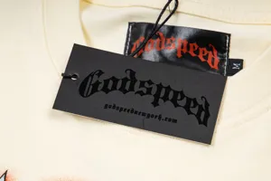 Close-up detail of streetwear t-shirt neckline with Godspeed brand tag and M size label.