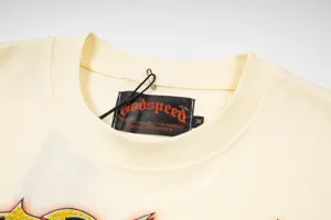 Close-up detail of cream streetwear t-shirt collar featuring black Godspeed brand label.