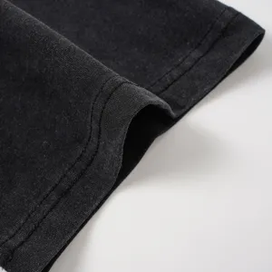Close-up of black washed cotton t-shirt fabric hem, showing fine double-needle stitching.