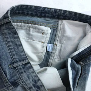 Detailed view of the denim shorts interior, showing sturdy stitching and washing label.