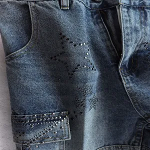 Close-up of casual denim shorts featuring metal stud pentagram star patterns and pocket details.