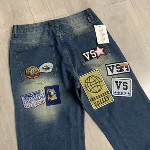 Λεπτομερής πίσω όψη τζιν παντελονιού streetwear με πολύχρωμα κεντημένα μπαλώματα και ετικέτες.