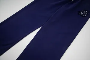 Λεπτομέρεια από σκούρο μπλε casual παντελόνι φόρμας με κέντημα με τρουκς και στυλ.