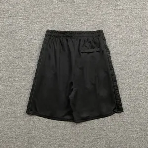 Κοντινό πλάνο σε μαύρο σορτς streetwear με ανάγλυφα γράμματα στα πλαϊνά μέρη.