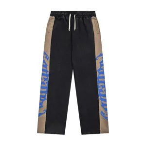 Detailed view of the streetwear colorblock sweatpants, highlighting the gothic side print.