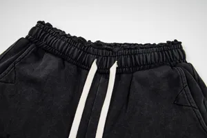 Black washed casual shorts featuring extra-long drawstrings and ruffled elastic waistband.
