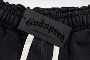 Close-up detail of distressed washed shorts waistband with black brand tag and drawstrings.